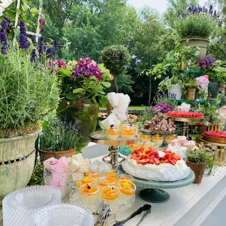 Dessert display table at a Sky Garden event with floral decorations and greenery