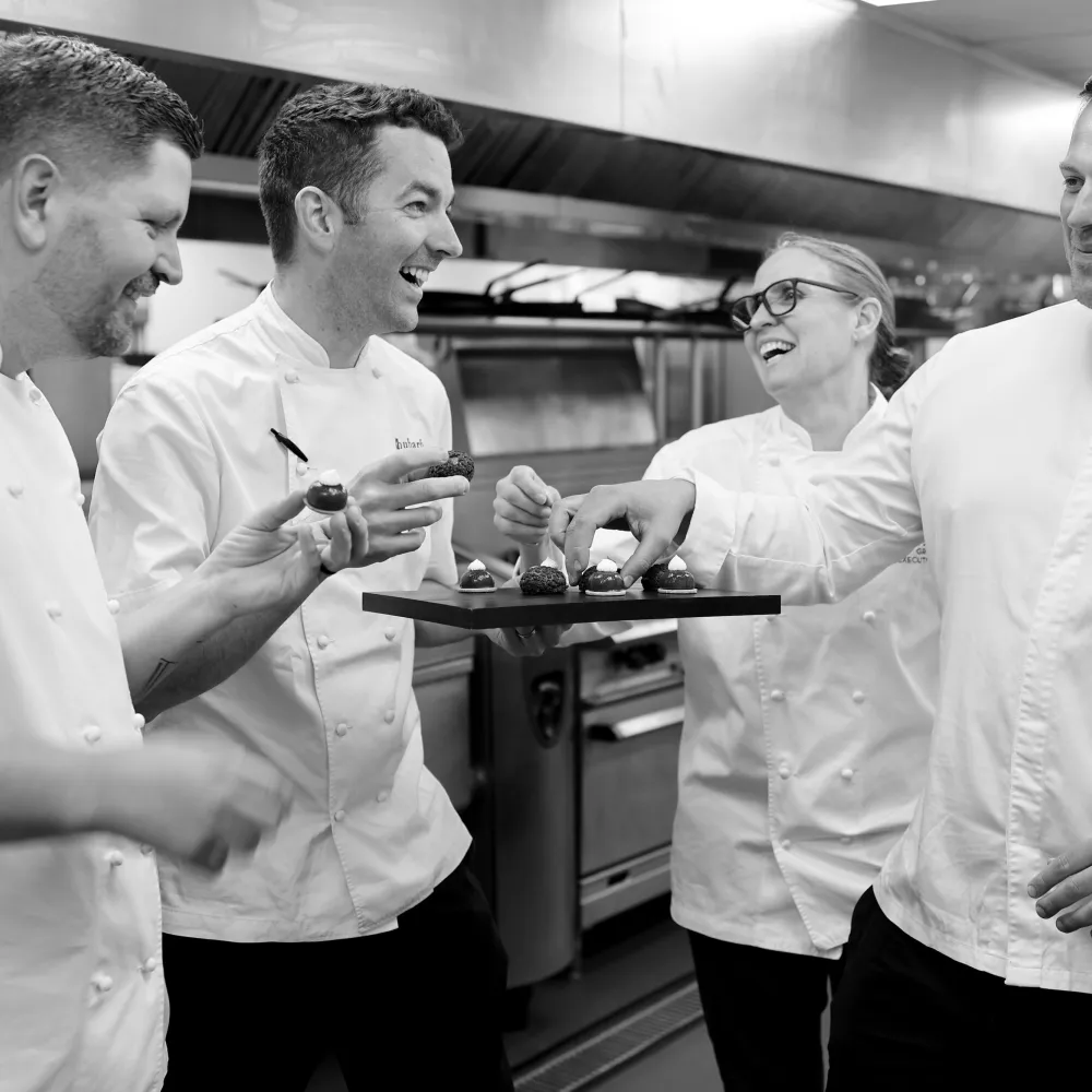 Chefs Laughing round a tray of food