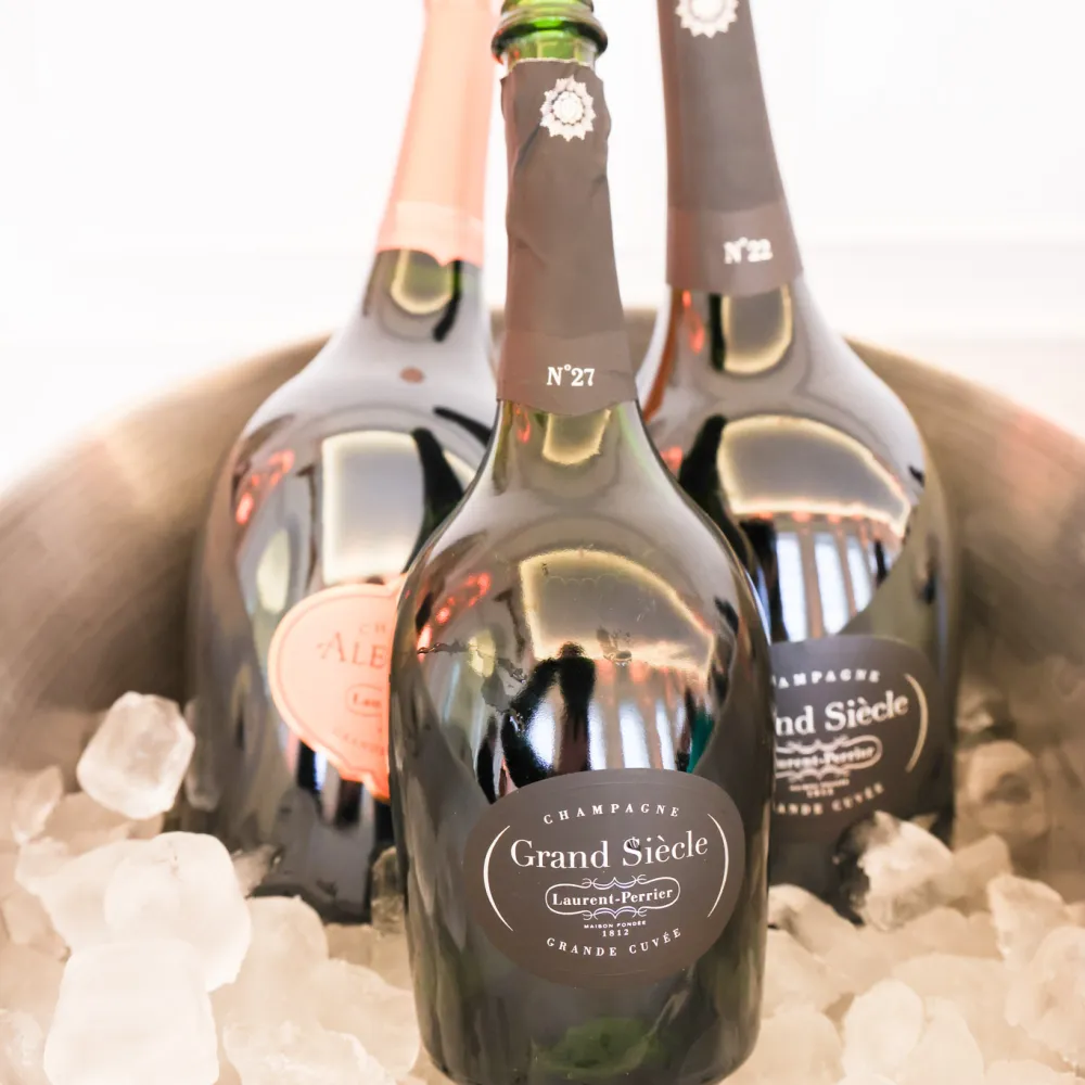 Bottles of Laurent-Perrier Champagne, including Grand Siècle, chilled on ice in a silver bucket, displayed at the drinks reception