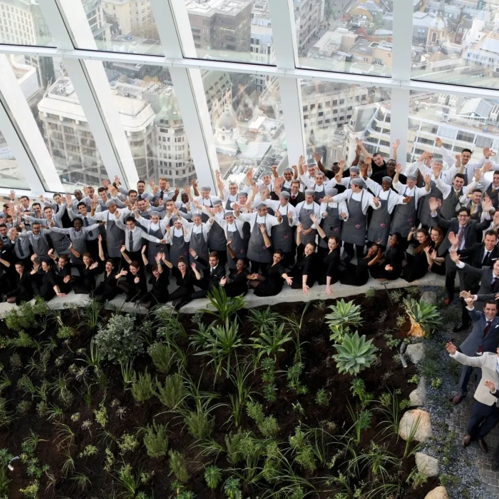 Staff gathered together in Sky Garden waving to the camera