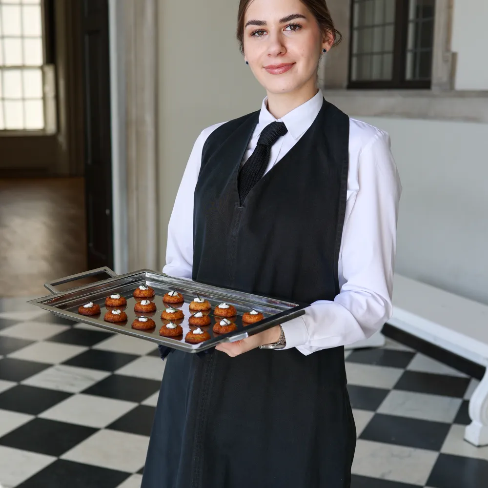 Waitress holding a plate of canapes in the hall of the Queens House Greenwich