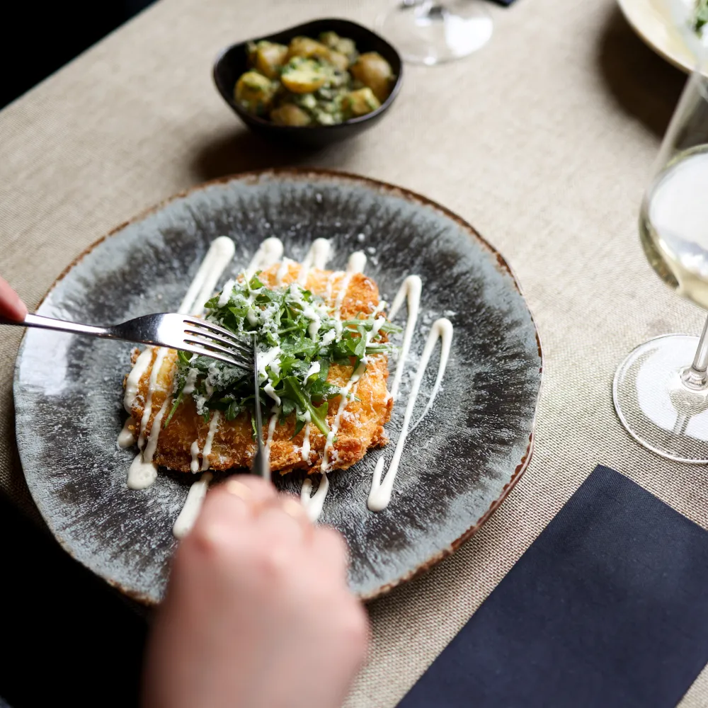Seasonal main course served with a glass of white wine at The Elgar Room