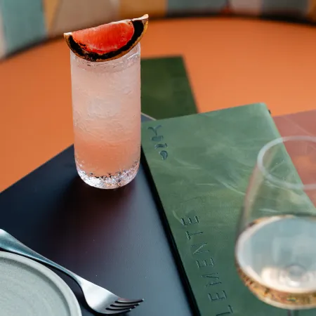 A glass of wine and a cocktail at a dining table in Elemente Hamburg