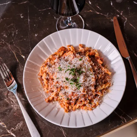 Pasta in a rich tomato and meat sauce topped with grated cheese and fresh herbs at Skywalker Grill.