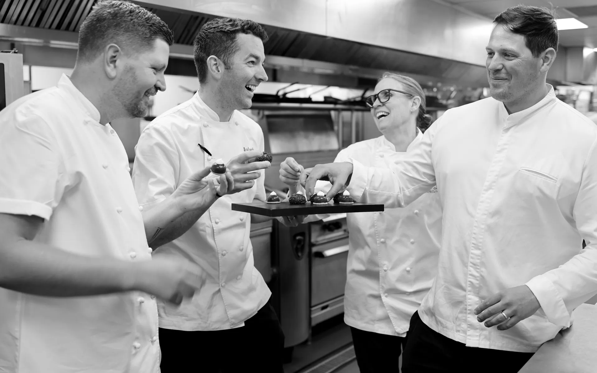 Chefs Laughing round a tray of food