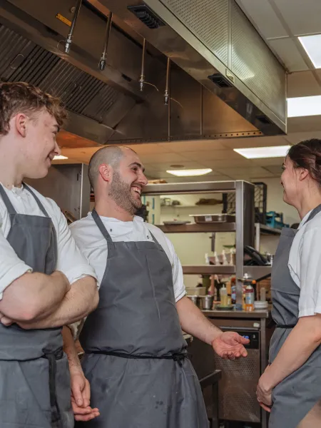 Chefs gathered, talking and planning in the kitchen