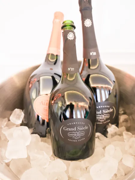 Bottles of Laurent-Perrier Champagne, including Grand Siècle, chilled on ice in a silver bucket, displayed at the drinks reception