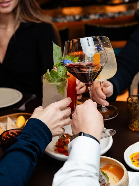 Guests toasting drinks at a table inside Elemente Hamburg