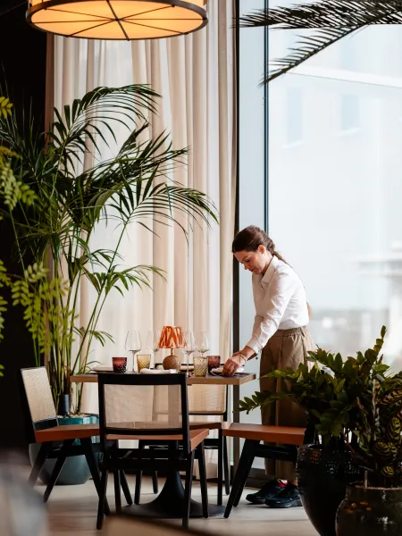 Waitress preparing the table inside Elemente Hamburg