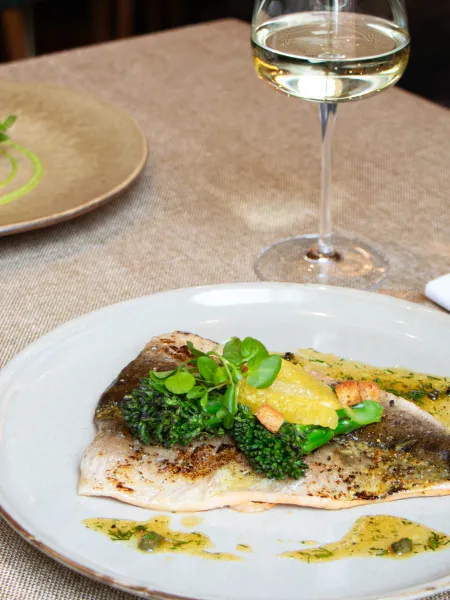 Seasonal main course served with a glass of white wine at The Elgar Room