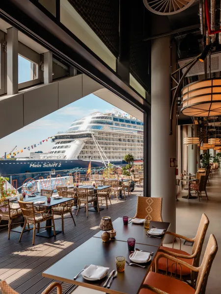 Outdoor dining at Air Bar 13 overlooking the harbour and a cruise ship.