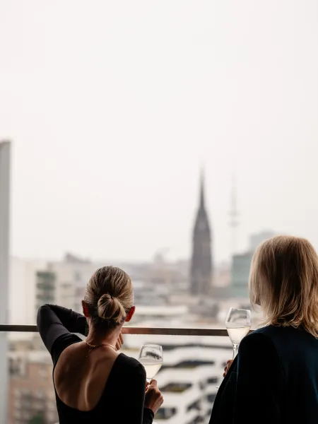 Guests enjoying drinks with views across the Hamburg skyline from the rooftop..