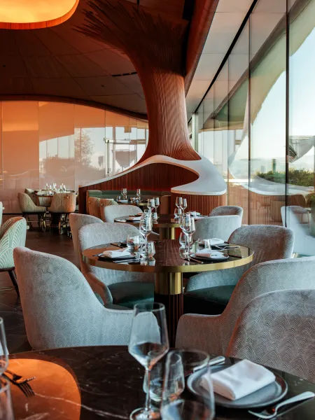 Skywalker Grill restaurant interior with curved wooden ceilings, contemporary seating focusing on tables