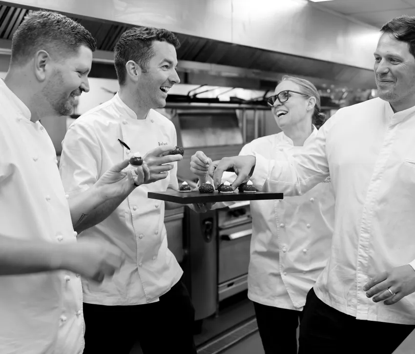 Chefs Laughing round a tray of food