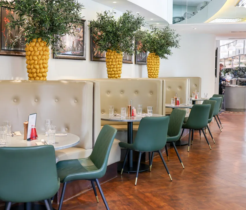 **Dining area with booth seating and lemon tree vases at the Verdi, Royal Albert Hall**